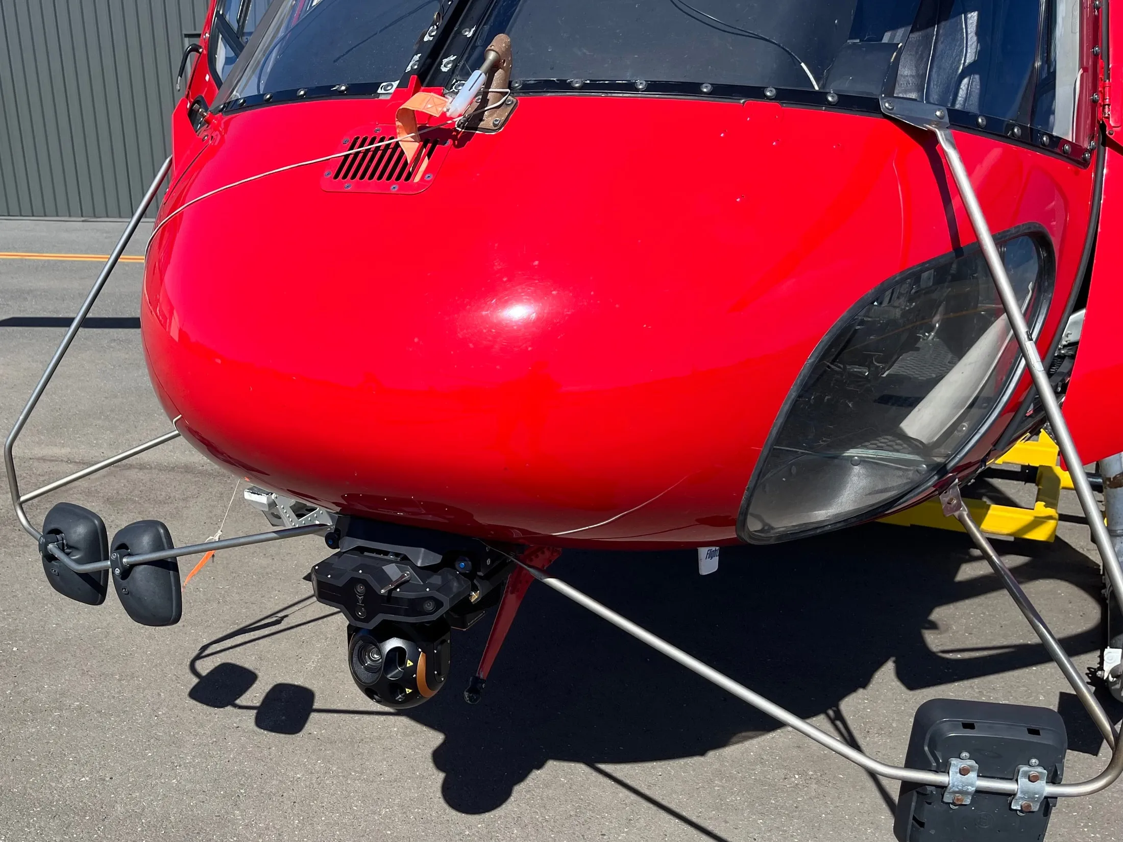 Sensores y torreta VoxVision instalados bajo el morro de un helicóptero rojo